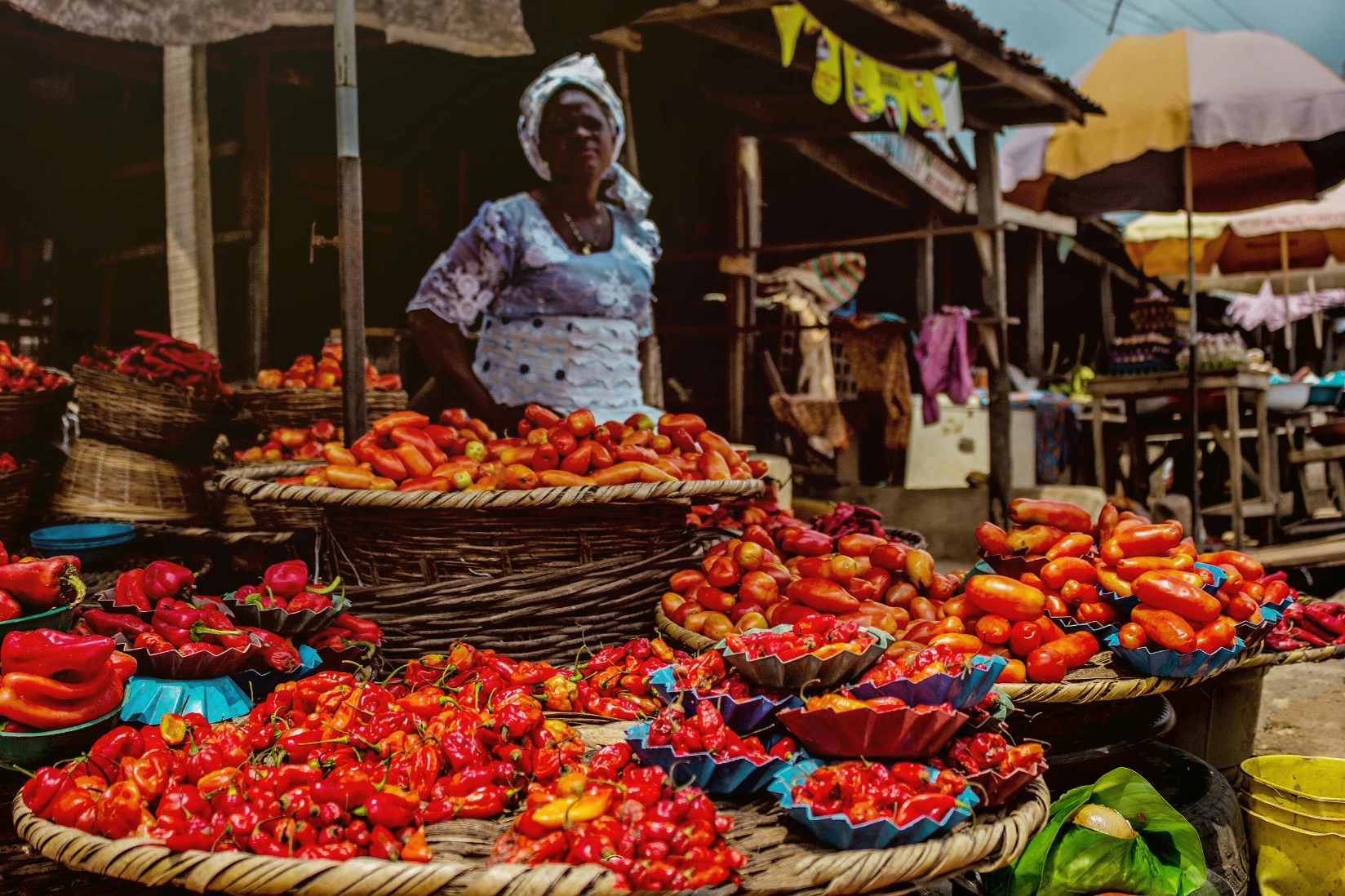 a woman selling tomatoes and pepper